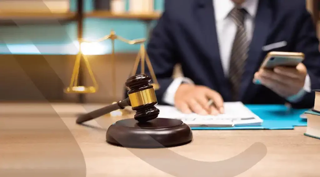 Legal professional reviewing documents on compliance and risk management in law office with gavel and scales of justice.